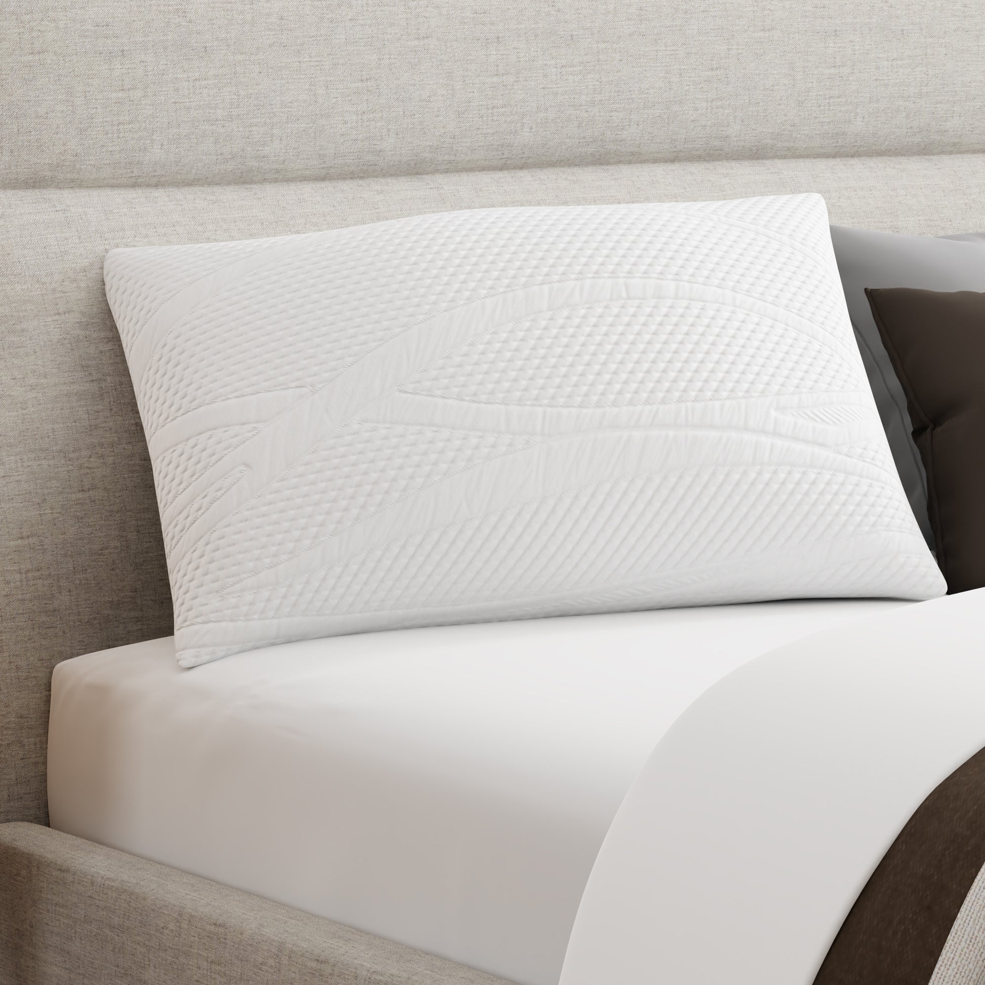 Owen Holmes Essentials Pillow resting on bed with soft white cover and modern stitching