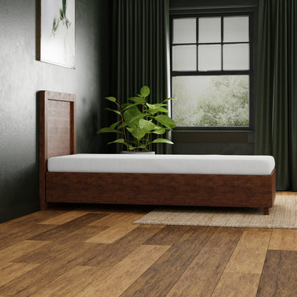 Wooden bed with white mattress in a room with a window and plant