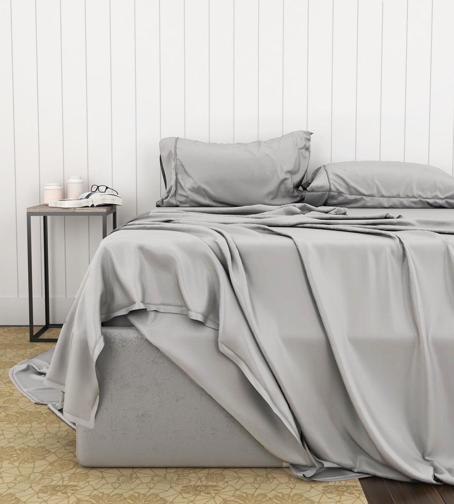 Gray bamboo luxury sheet set on a bed with a white wooden headboard.