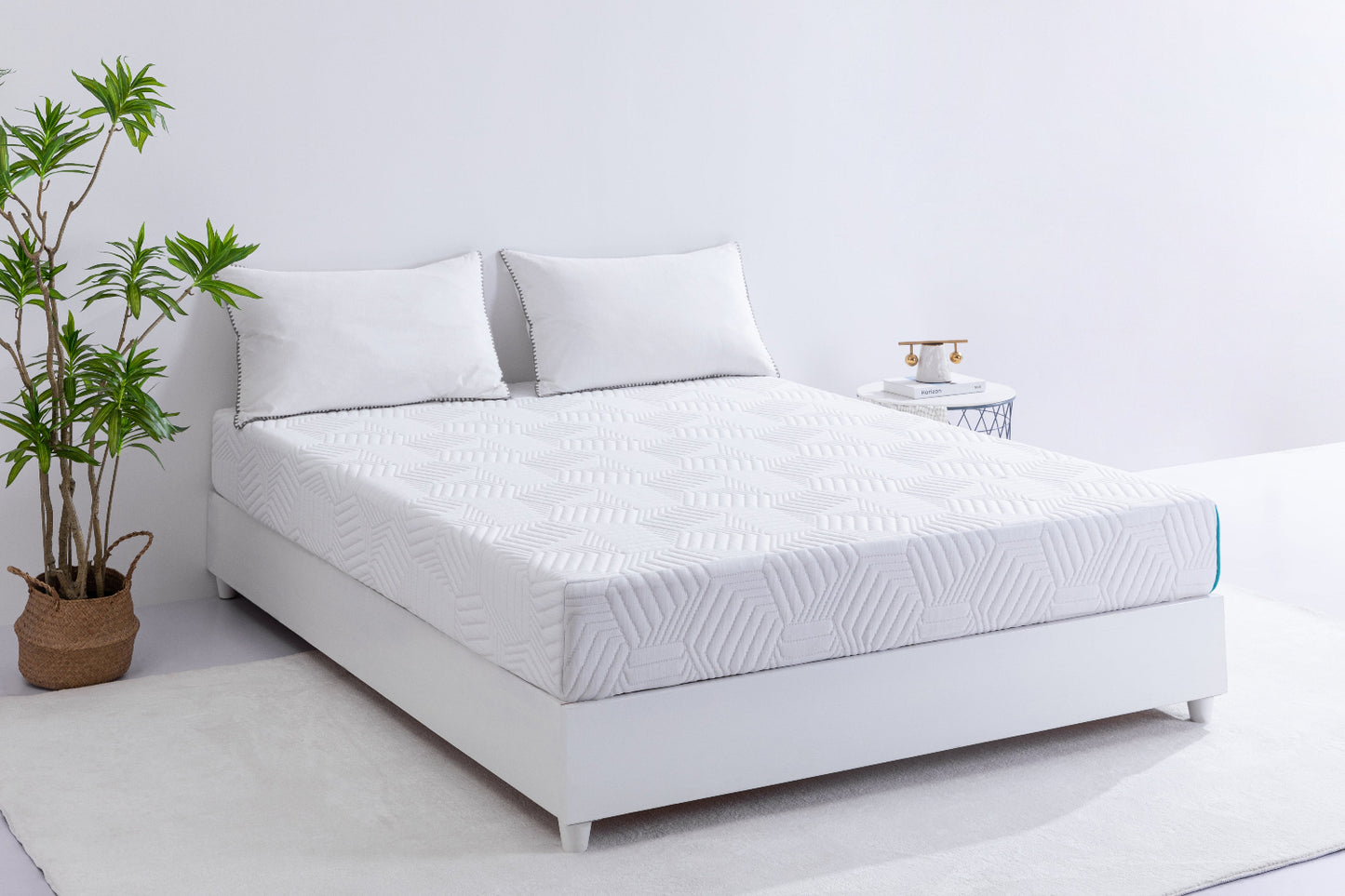 White 8-inch foam mattress on a bed with pillows and a plant in the corner.