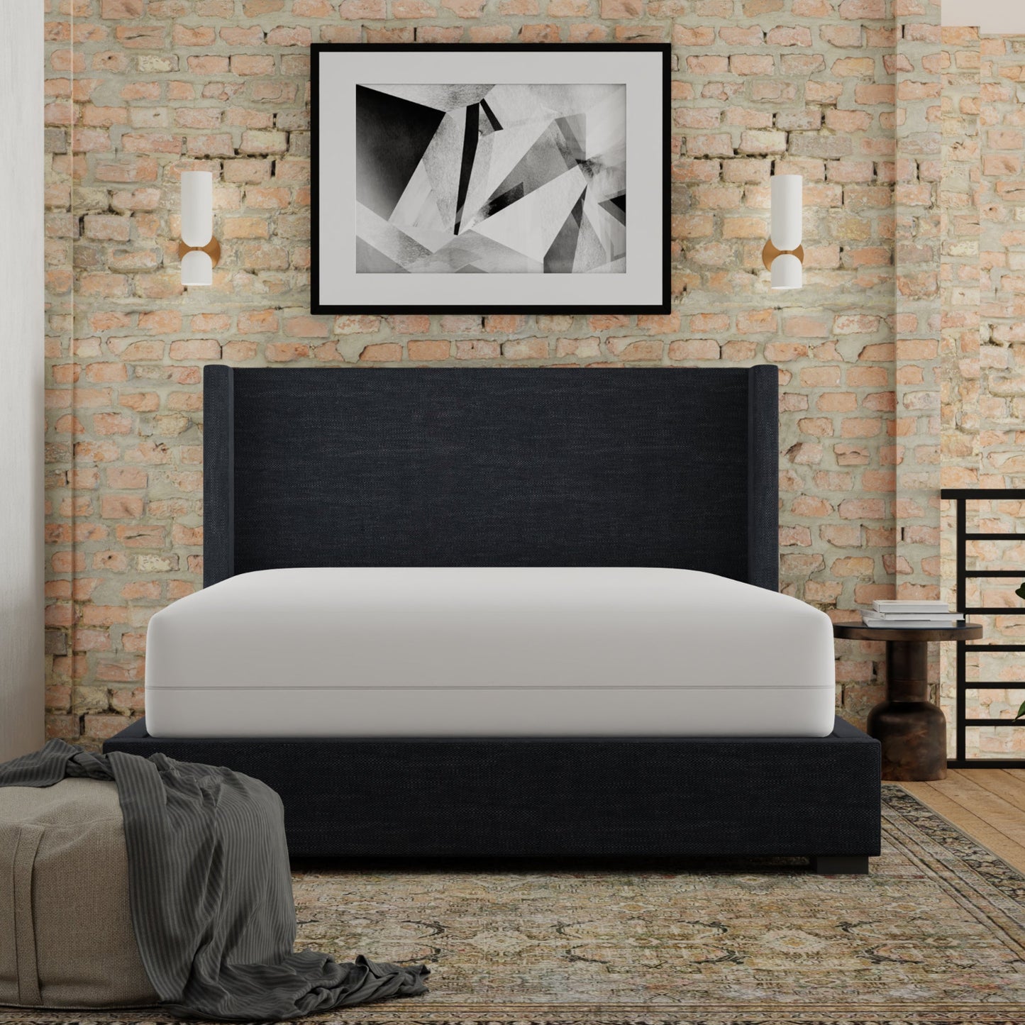 Modern bedroom with a black upholstered bed against a brick wall. Mattress has Igloo-Mattress_encasement_protector