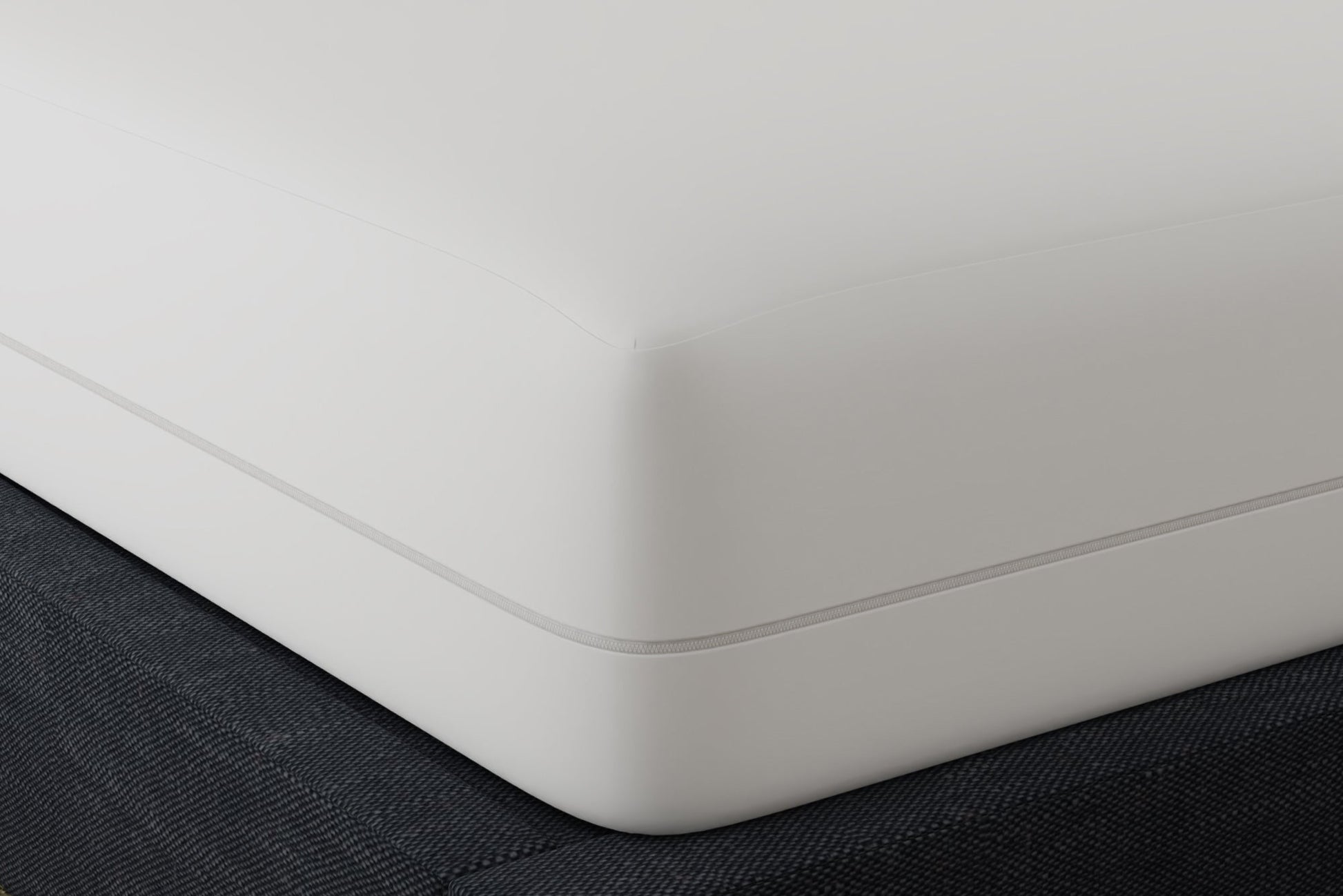 White mattress encasement on a bed with a dark fabric surface