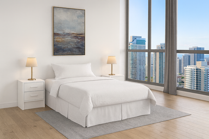 Queen size steel platform bed base completely dressed with white sheets, pillow and comforter in a bedroom with a view of a downtown city