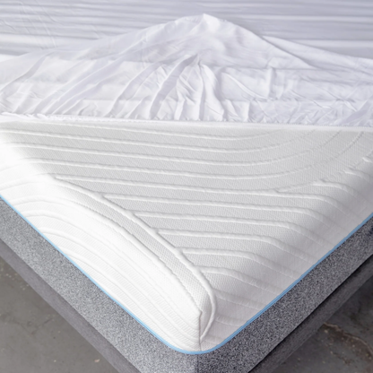Close-up of a mattress protector with a gray base and white top on a plain background.